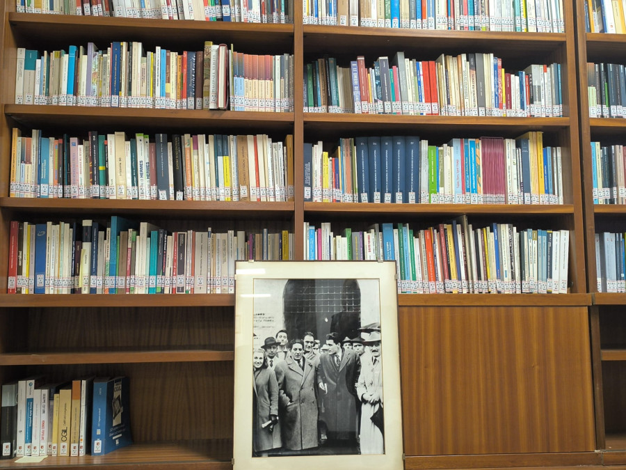 l'immagine mostra una libreria con molti libri, e in basso appoggiata una cornice rettangolare con all'interno una fotografia che mostra alcuni uomini, tra cui Giuseppe Di Vittorio